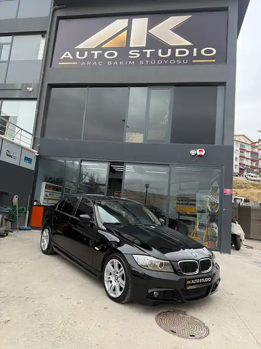 AK Auto Studio tabelasının altında parlak siyah BMW 3 Serisi