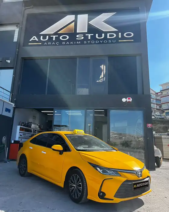 Taksi sarısına kaplanmış Toyota Corolla AK Auto Studio'nun önünde
