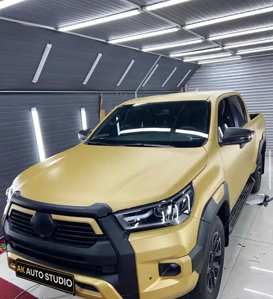 Mat altın folyoyla kaplanmış Toyota Hilux atölyede